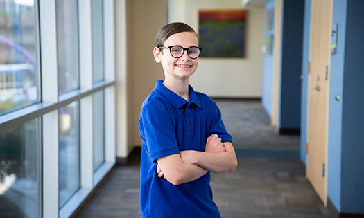 Aiden, smiling and posing in a hallway